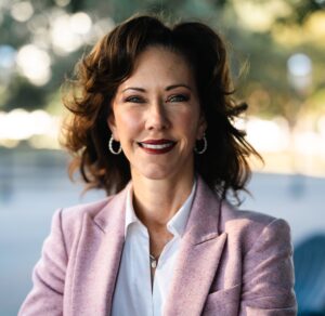headshot of CEO of friends of foster care in pink blazer.